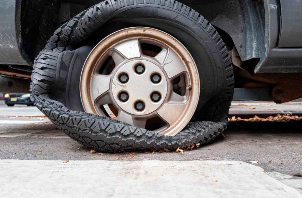 rueda desinflada por el desgaste causado por el calor en la carretera